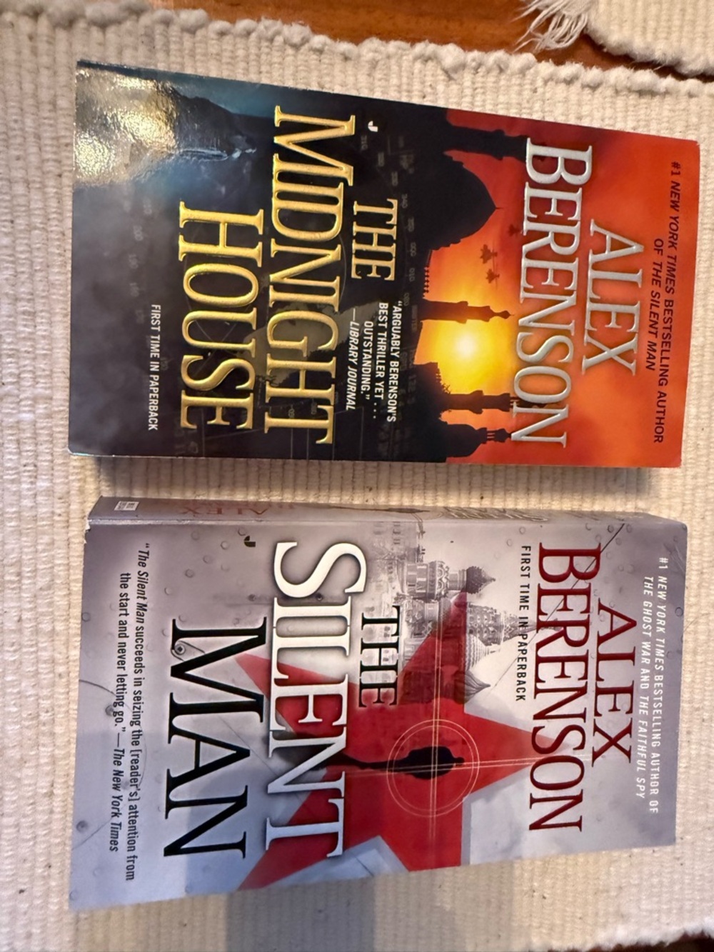 2 paperback books by Alex Berenson, The Silent Man and The Midnight house